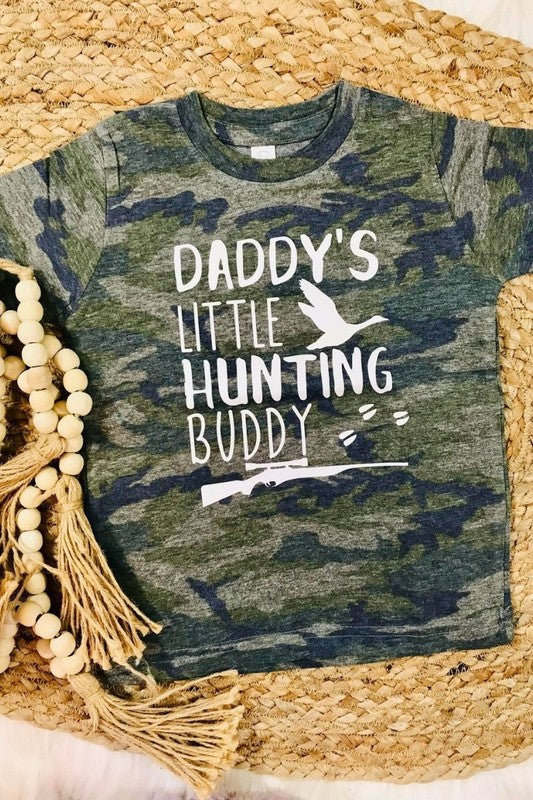 A vintage camouflage colored t-shirt with the text 'Daddy's Little Hunting Buddy' printed on the front.