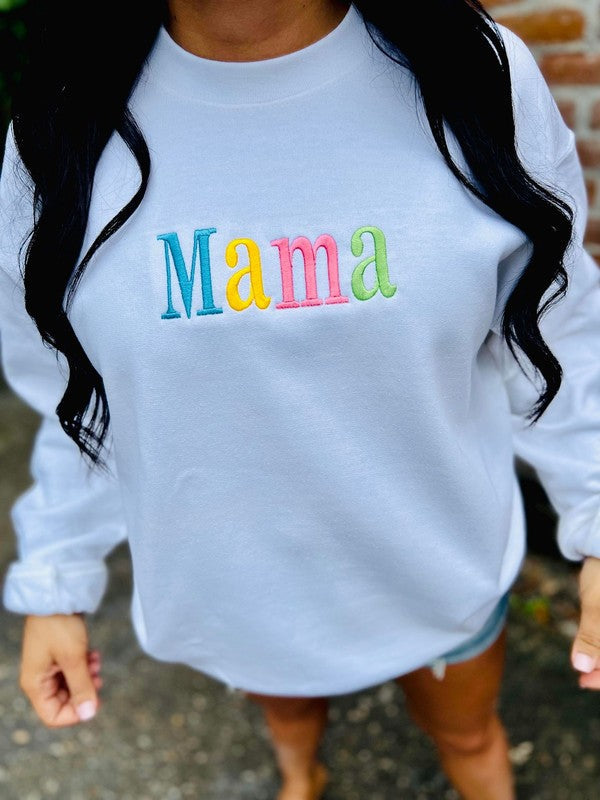 A white sweatshirt with the word 'mama' embroidered in multicolored letters on the front.